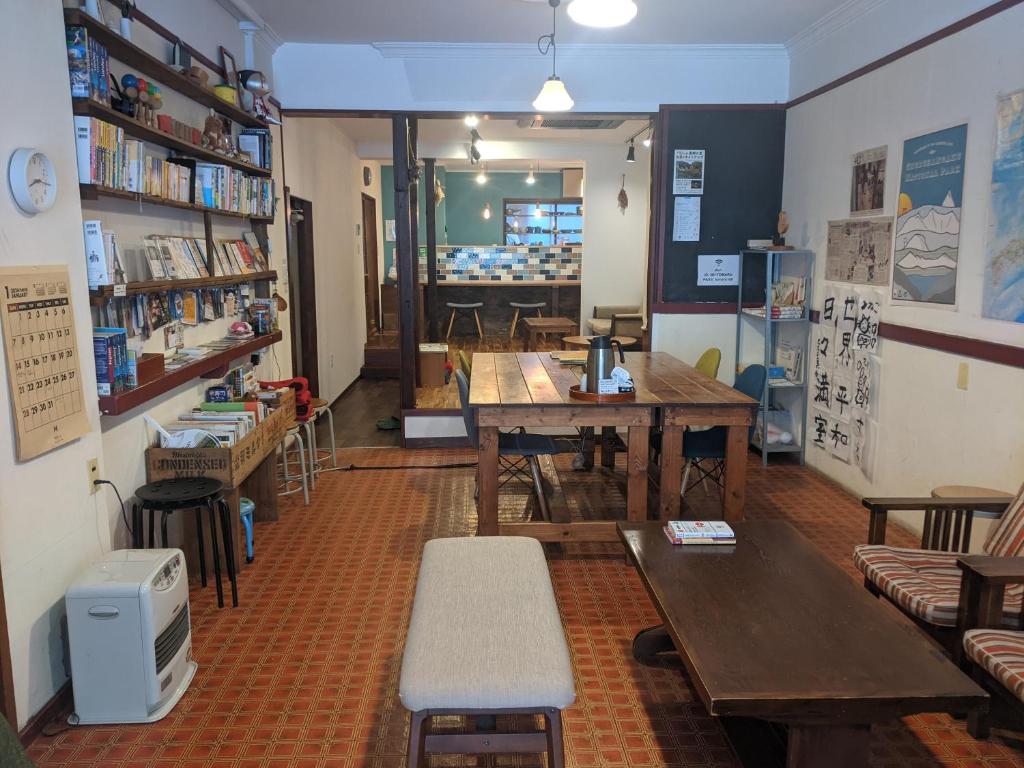 una stanza con tavolo e panche in una libreria di Guesthouse Tomaru a Takayama