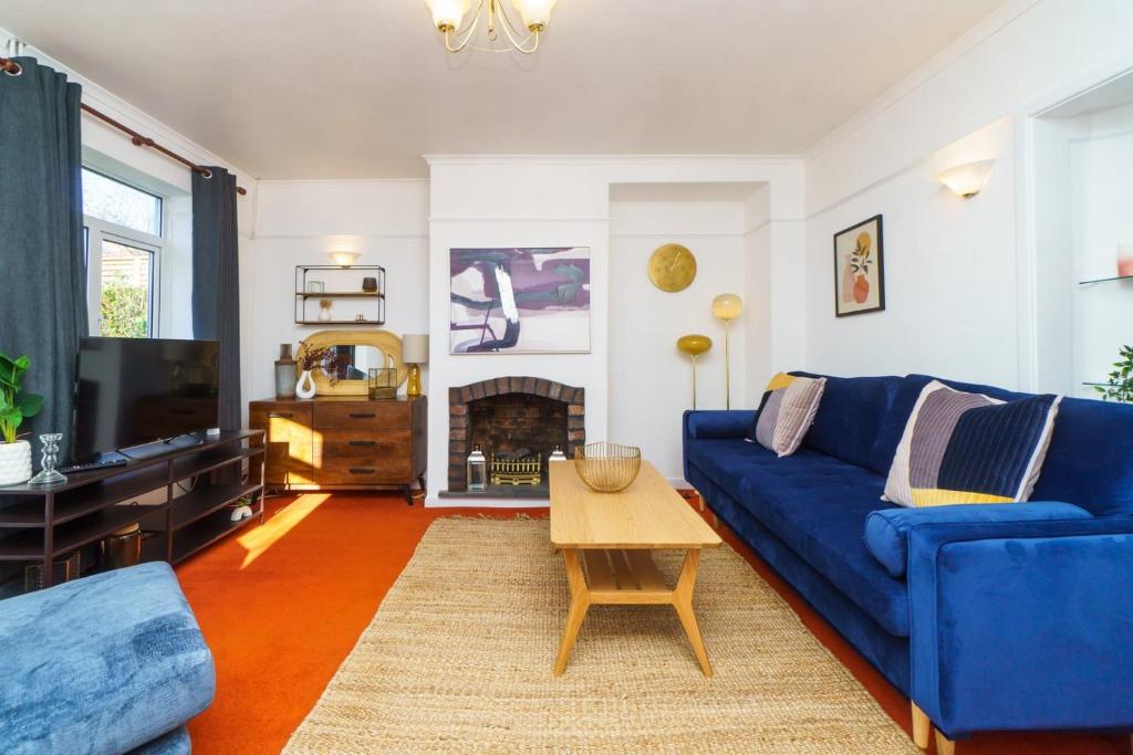 a living room with a blue couch and a tv at 4BR House | WiFi | Parking in Bristol