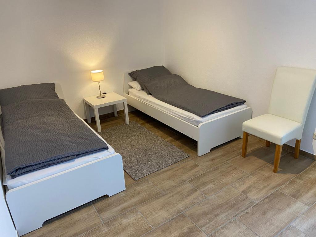 1 dormitorio con 2 camas y 1 silla en Ferienwohnung Kornkäfer 3, en Döbeln