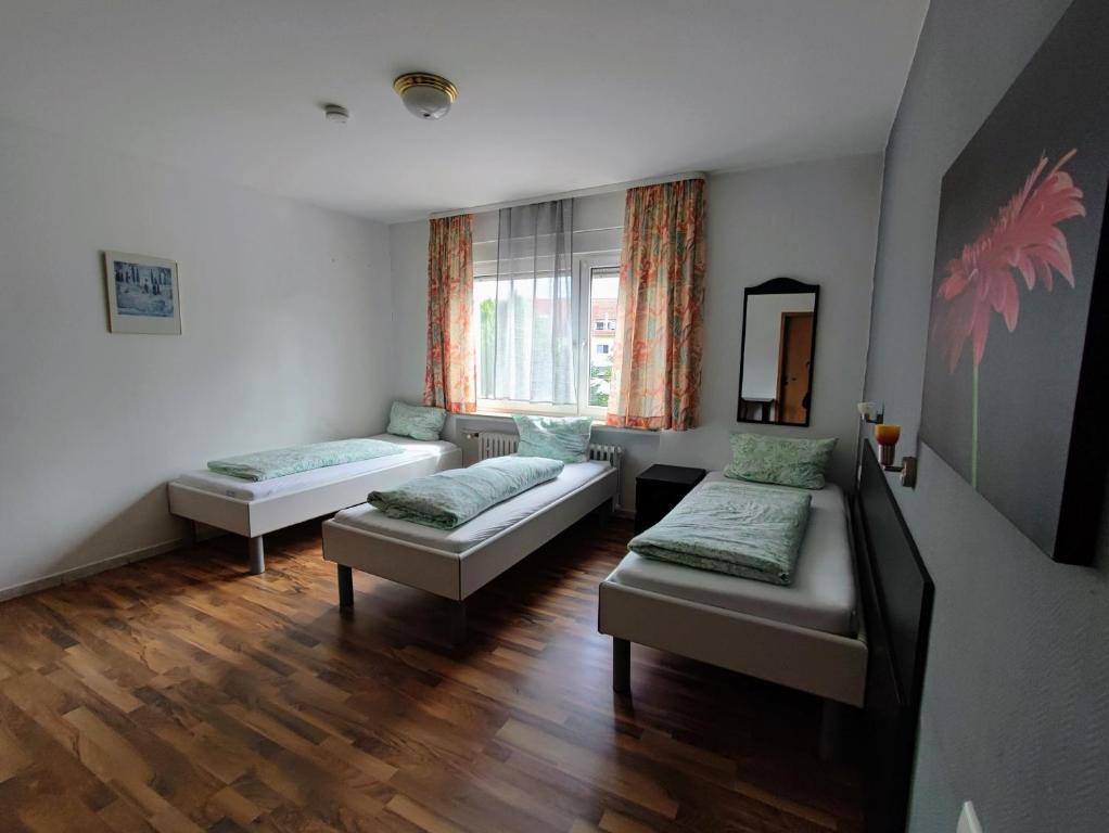 uma sala de estar com duas camas e uma janela em Monteurzimmer - Waldbronn em Waldbronn