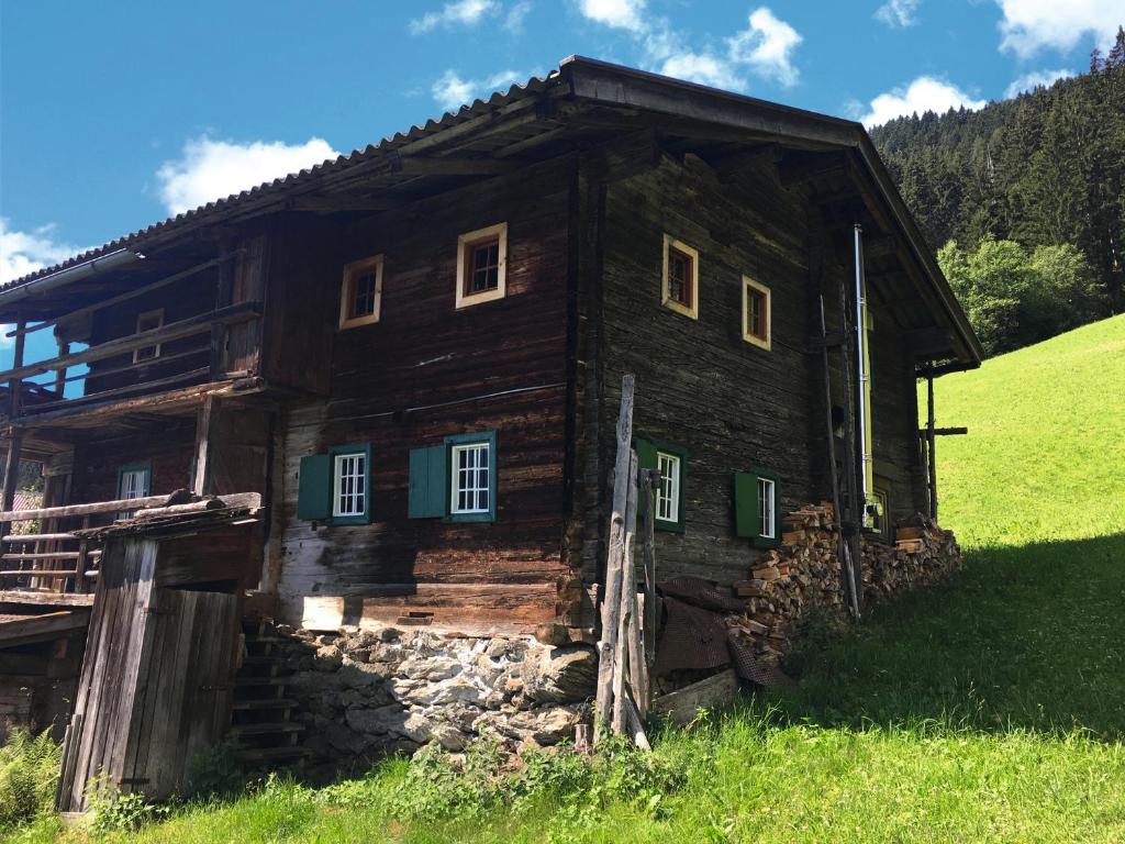 uma velha casa de madeira num campo relvado em Goass'n Alm Zillertal em Hippach