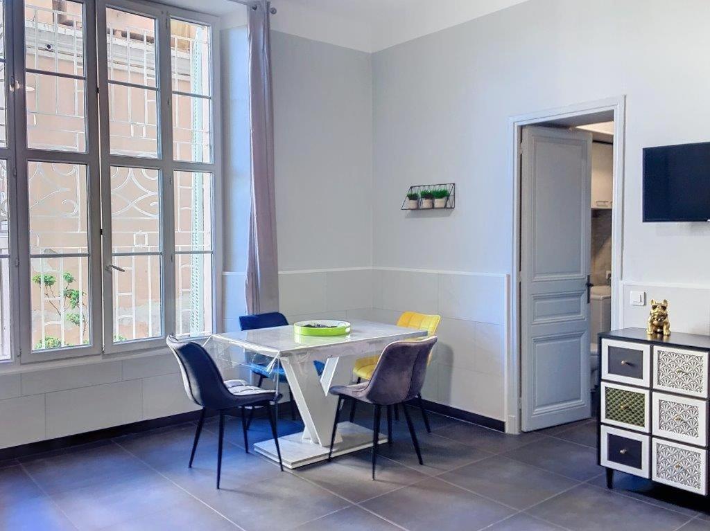 une salle à manger avec une table et des chaises blanches dans l'établissement Charmant studio, à Cannes