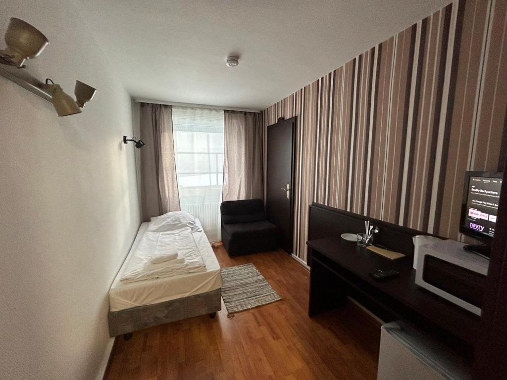Habitación pequeña con cama y escritorio. en WestEnd#104, en Frankfurt