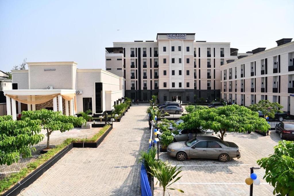 um parque de estacionamento com carros estacionados em frente a um edifício em VIEWPOINT HOTEL AND SUITES em Benin City