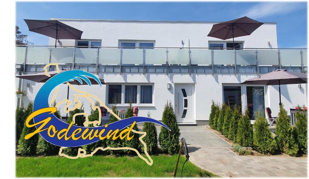 a white house with a sign in front of it at Ferienwohnungen "Godewind", Appartements mit Balkon oder Terrasse in Zinnowitz