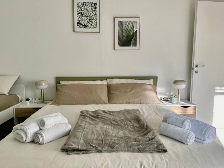 een slaapkamer met een bed met handdoeken erop bij [near Orio] BGY Malpensata HOUSE in Bergamo
