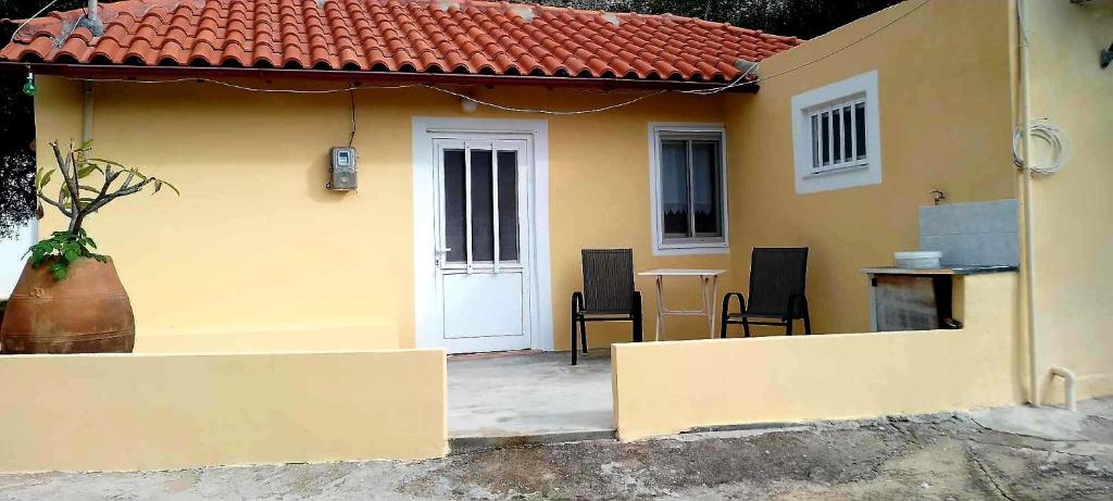 a small yellow house with a table and chairs at Despina's House in Sitia