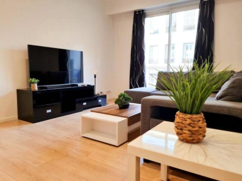 un salon avec un canapé et une télévision dans l'établissement Appartement Nice avec balcon et parking privé, à Nice