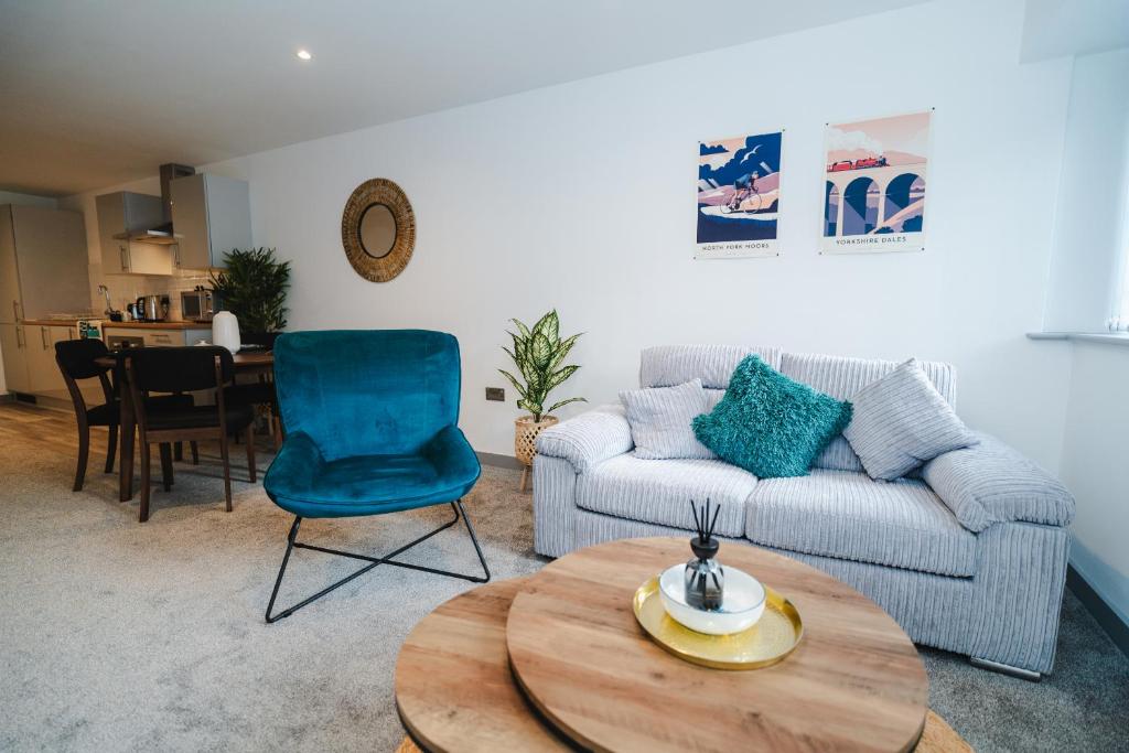 een woonkamer met een bank en een tafel bij George House Modern Apartments by VICHY in Hull