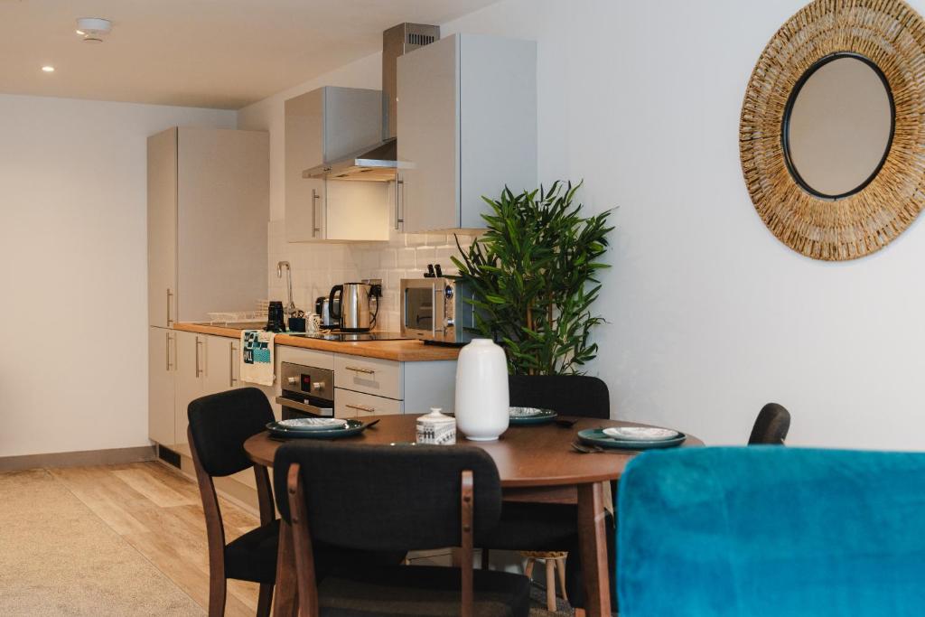 a kitchen with a table and chairs and a dining room at George House Modern Apartments by VICHY in Hull
