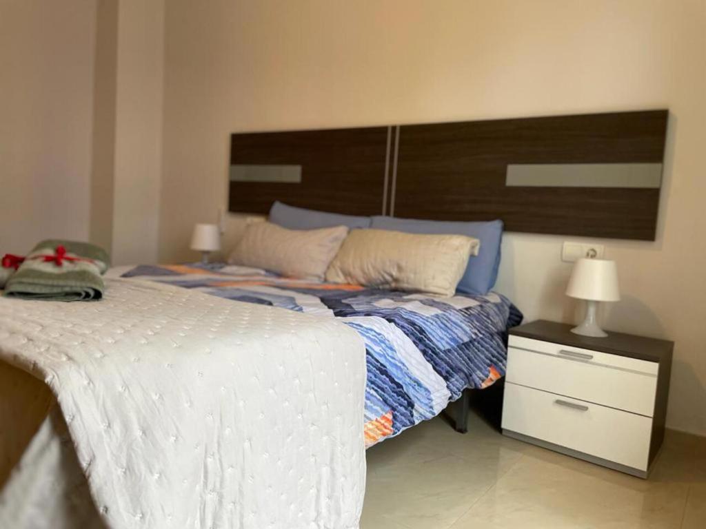 a bedroom with a large white bed and a night stand at KAIROS HOME y Garaje , Algemesí Home in Algemesí