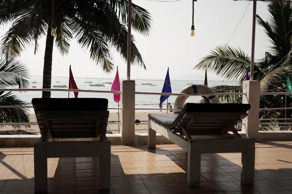osoba siedząca na ławce patrząca na plażę w obiekcie Saritas Guest House - Bogmalo Beach w mieście Bogmalo