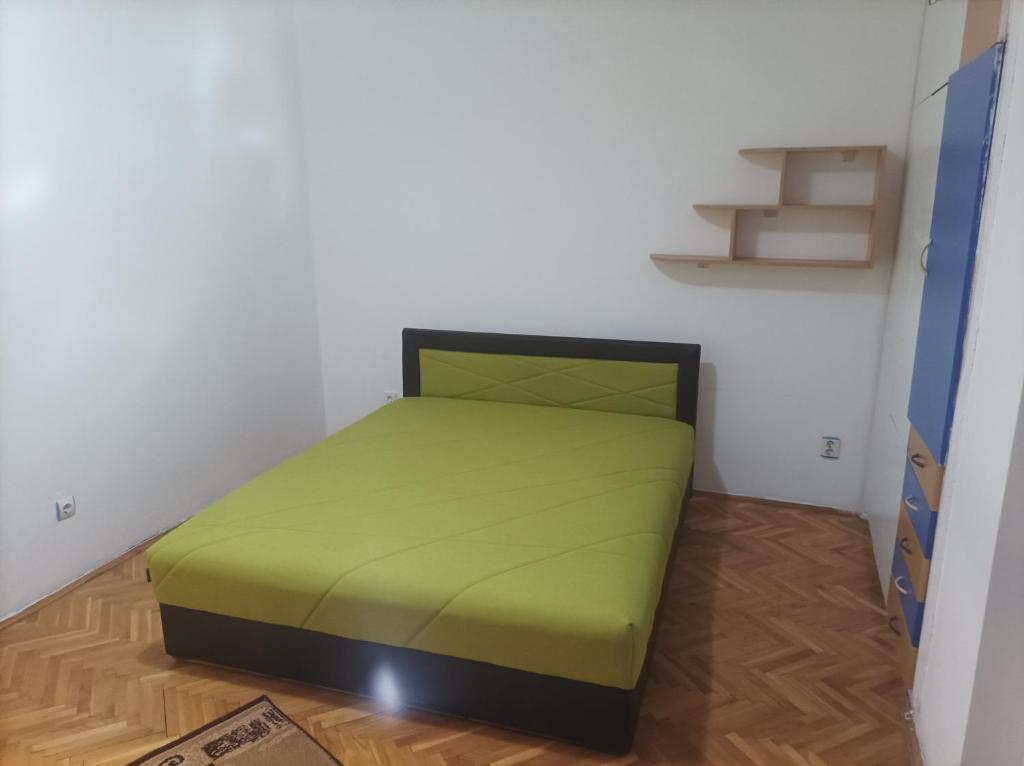 a bedroom with a green bed in a room at Стан in Prilep