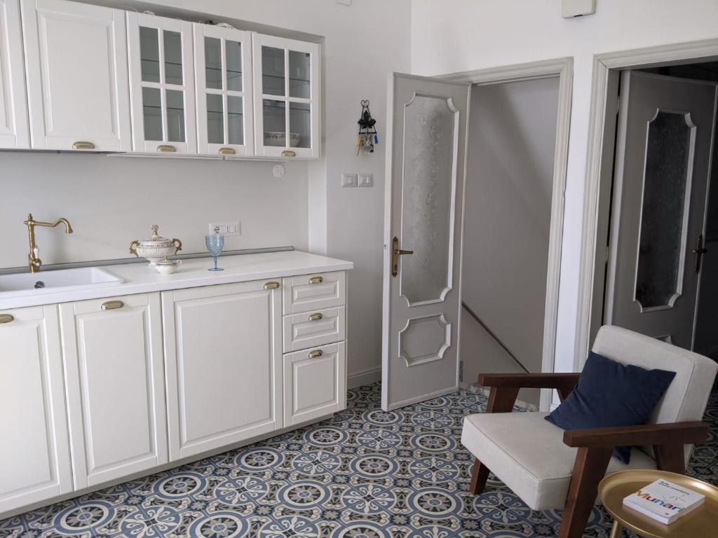 una cucina con armadi bianchi, sedia e doccia di Casa panoramica 