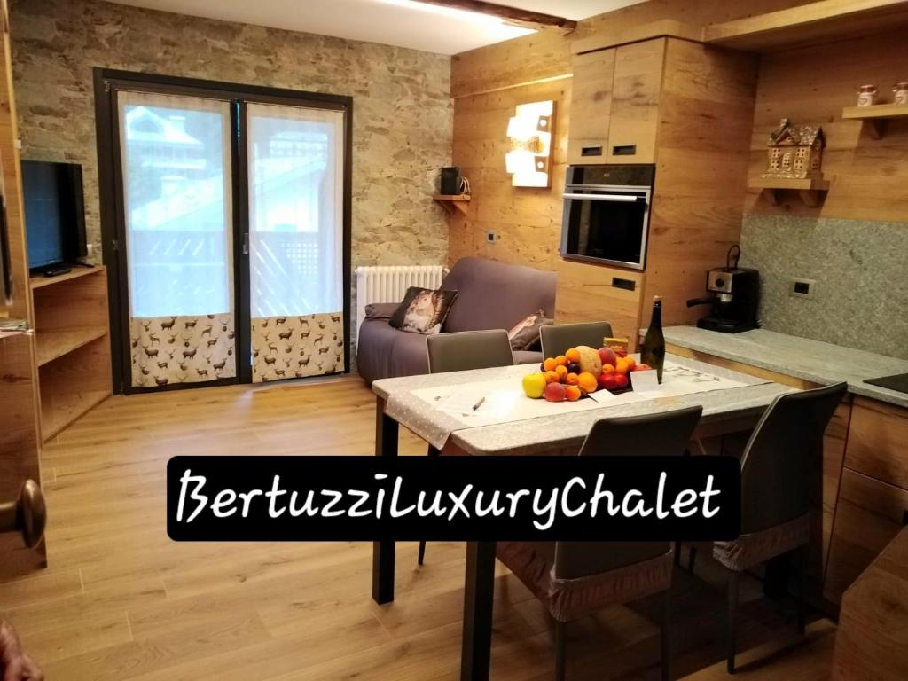 a kitchen and a living room with a table at Bertuzzi Luxury Chalet in Aprica