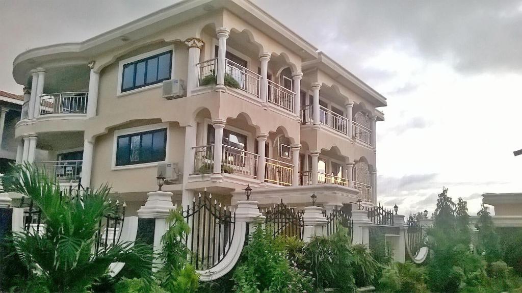 MAYRAH Inn - Your comfortable home from home in Freetown Sierra Leone في Goderich: مبنى ابيض كبير عليه بلكونات