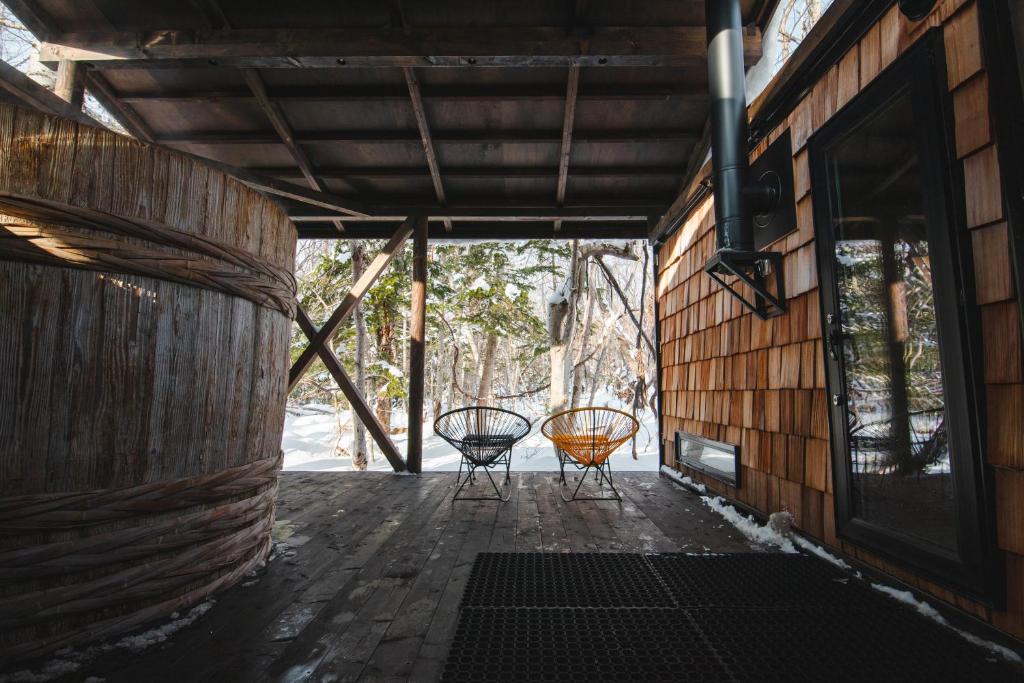 two chairs sitting on a porch of a house at Kussharoko Sauna Club in Teshikaga