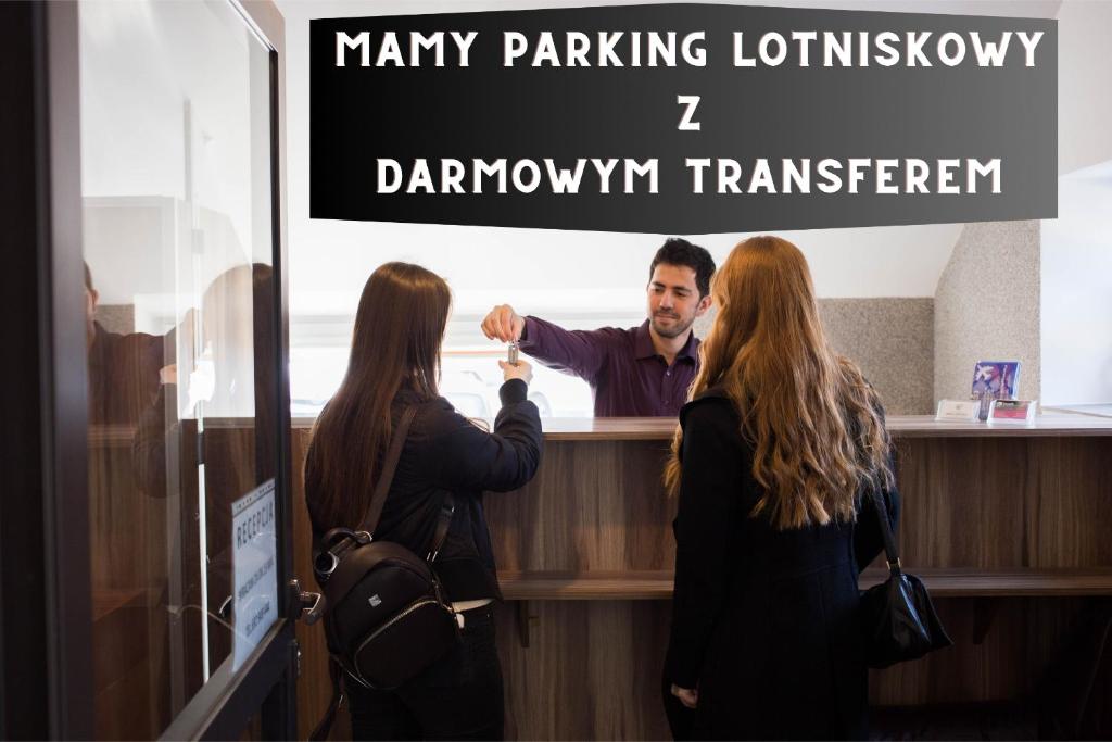 a man standing at a bar with two women at Hotelik Okęcie 39 - Parking i transfer na lotnisku in Warsaw