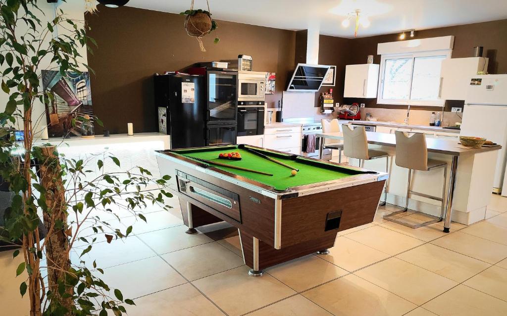 a kitchen with a pool table in a kitchen at Au Vendangeoir chambres d'hôtes in Couvignon