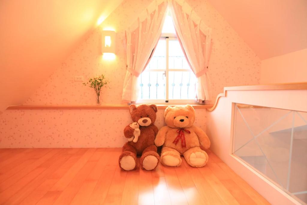 two teddy bears sitting in the corner of a room at Sigma Castle in Yuanshan