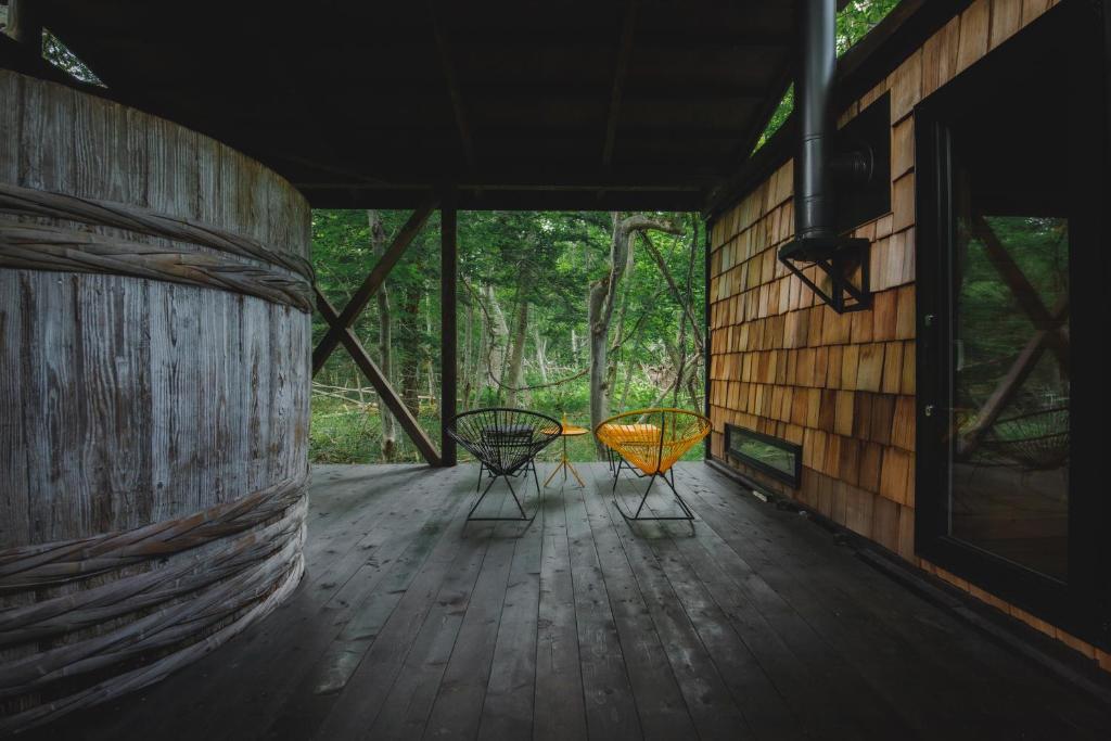 dos sillas sentadas en el porche de una casa en Kussharoko Sauna Club, en Teshikaga