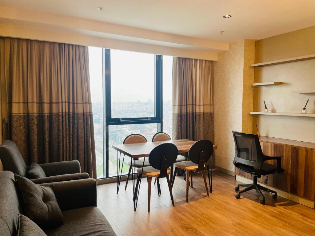 - un salon avec une table, des chaises et une grande fenêtre dans l'établissement Gül Proje1 -Amazing apartment with great view, à Istanbul