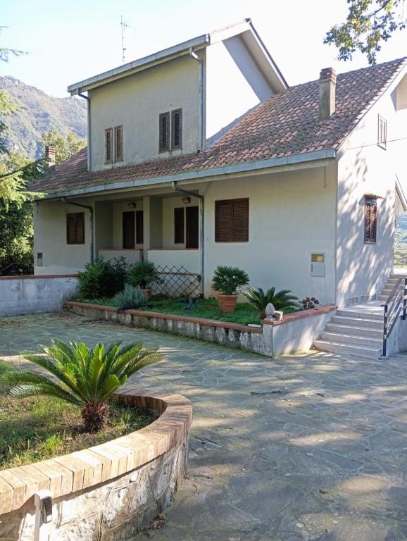 een wit huis met een stenen oprit bij Villa Kenia Flora in Maratea