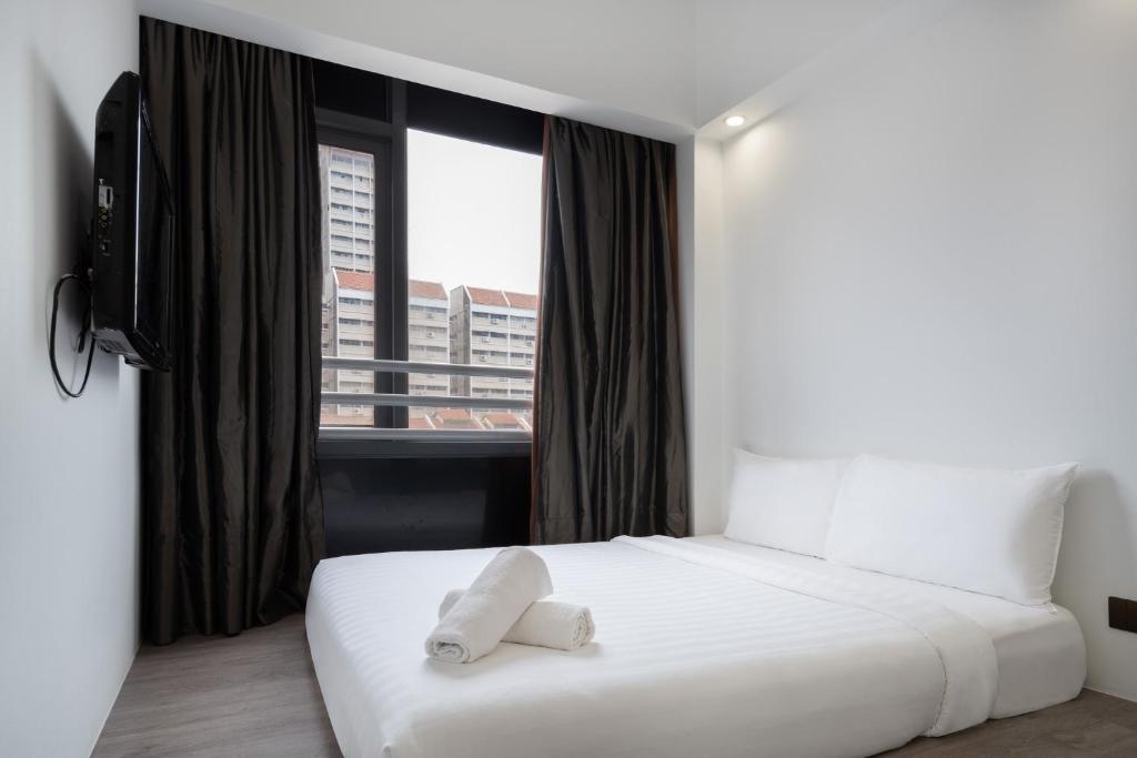 a white bed in a room with a window at Lion Peak Dickson in Singapore