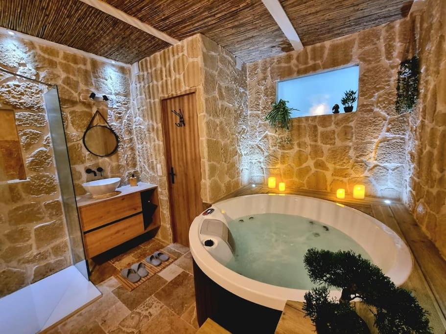 un ampio bagno con vasca e lavandino di Les Spas de la mer, Suite & Spa, Love room, Plein Cœur du Grau a Le Grau-du-Roi