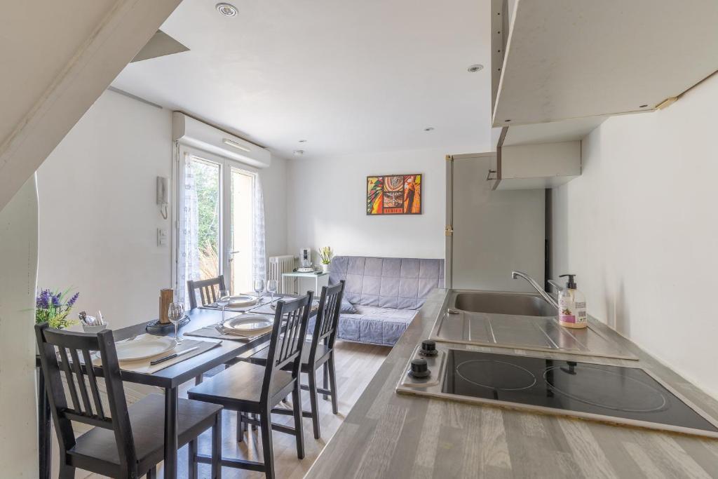 a kitchen and dining room with a table and chairs at Le Haut-Lévêque - Appartement cosy et fonctionnel in Pessac