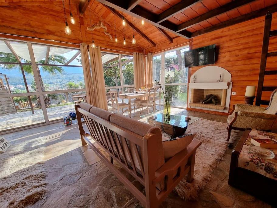 a living room with a bench and a fireplace at Ξύλινο Chalet Κτήμα Παππά in Levádeia