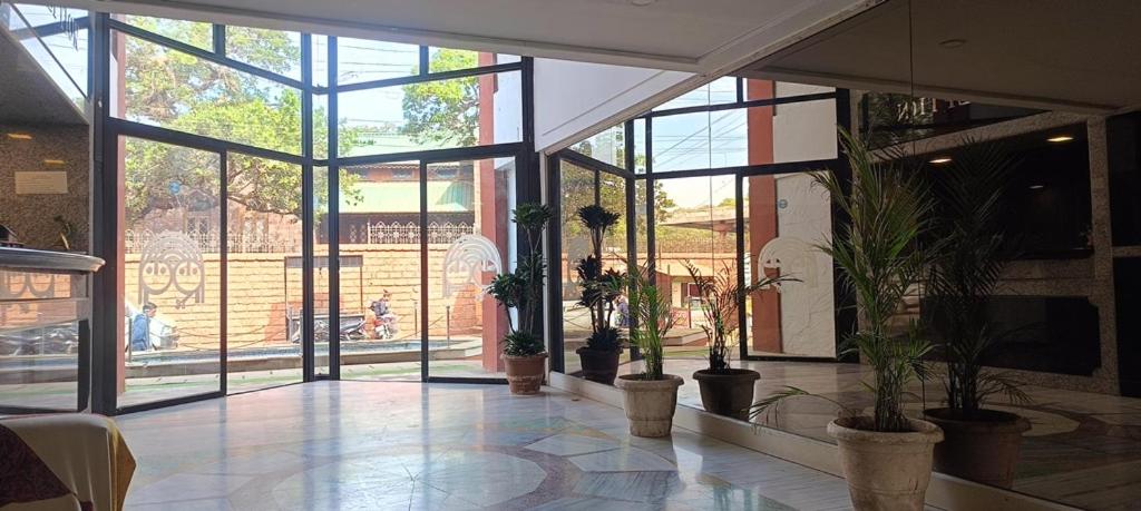 a lobby with potted plants in a building at Hotel Panorama Resorts in Mahabaleshwar