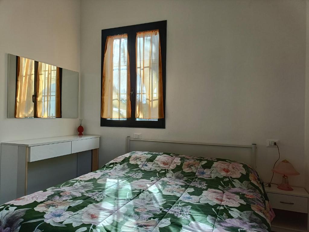 ein Schlafzimmer mit einem Bett und zwei Fenstern in der Unterkunft A Casa di Amici in Arezzo