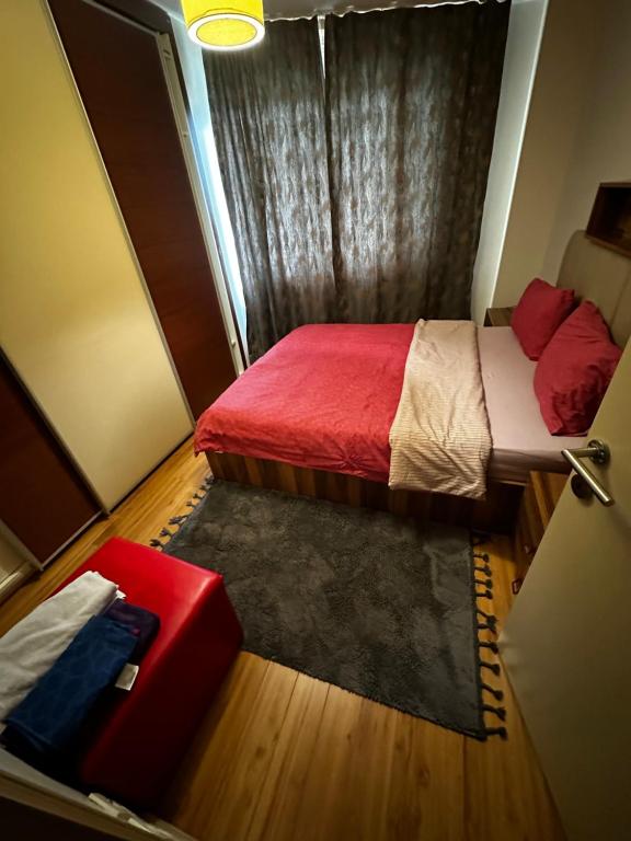 Habitación pequeña con cama y sofá rojo. en Atasehir Rezidans, en Estambul