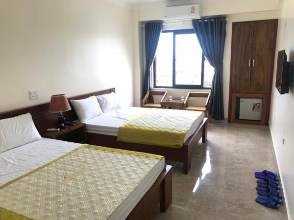 a hotel room with two beds and a window at Khách sạn Sơn Hiền Cửa Lò in Cửa Lò
