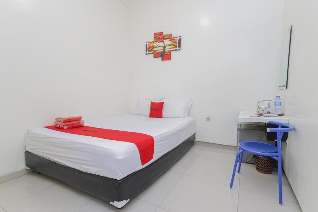 Kost K23 في سورابايا: غرفة نوم بسرير ومكتب في غرفة