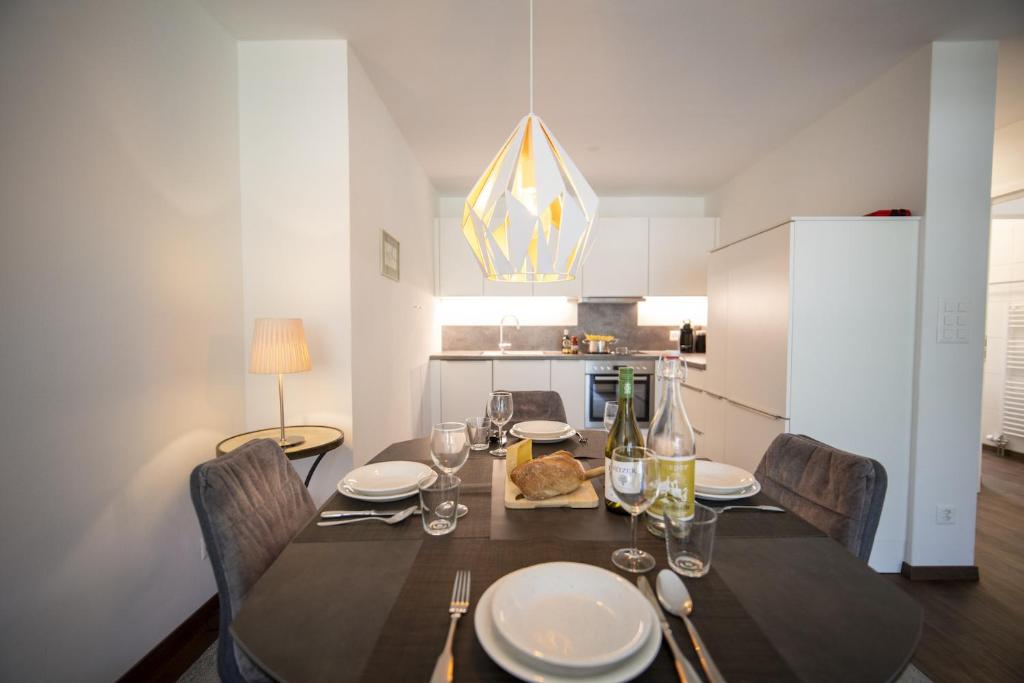 une salle à manger avec une table et des chaises ainsi qu'une cuisine dans l'établissement Brentschpark 33, à Scuol