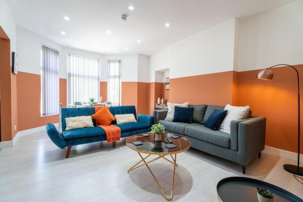 una sala de estar con 2 sofás azules y una mesa. en Cohost Partners | Stylish and spacious 1Br en Newport