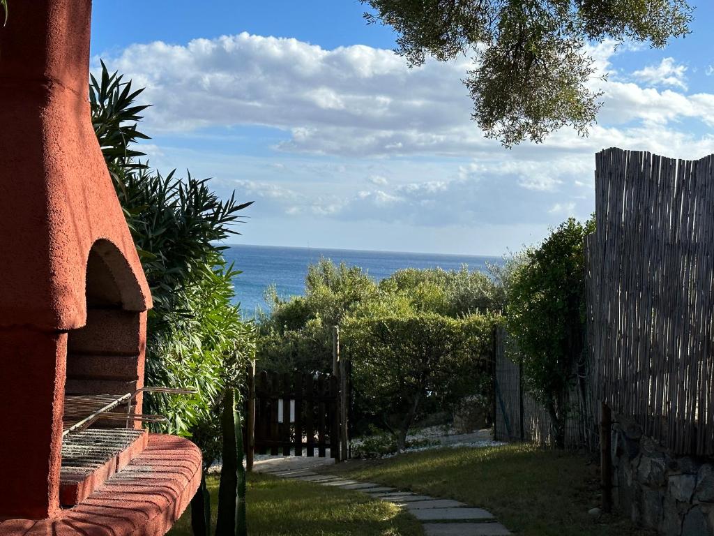 a view of the ocean from a house with a fence at Domus Tom Apartment with sea view Villasimius in Simius