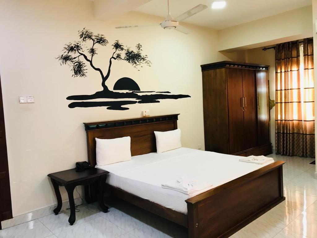 1 dormitorio con 1 cama con un mural en la pared en Hotel Royal Grand Paradise, en Kelaniya