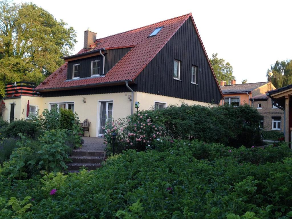 a house with a red roof and some bushes at Ferienwohnung Himmelpfort in Himmelpfort