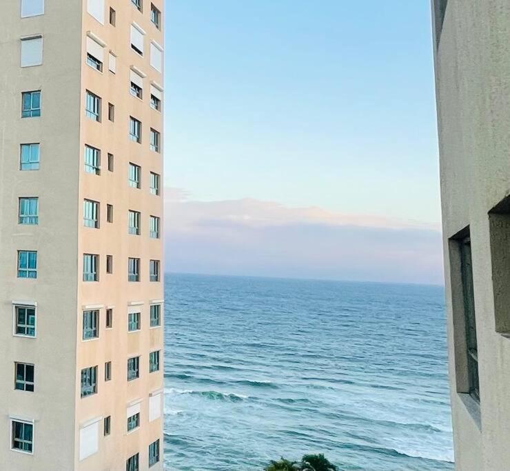 a view of the ocean from between two buildings at Apartamento con vista mar La Paz en Malecón Santo Domingo in Santo Domingo