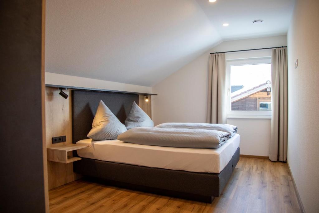 a bedroom with a large bed with a window at Das Steinach in Pfronten