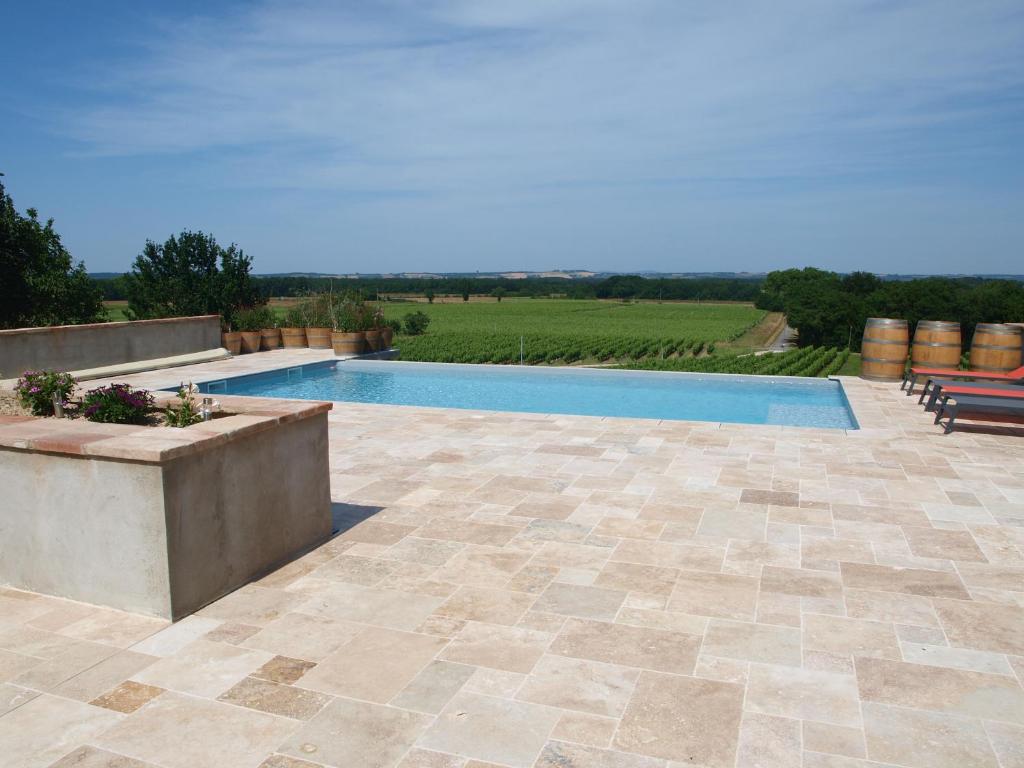 a swimming pool in a yard with a patio at Domaine de Codeval in Fronton