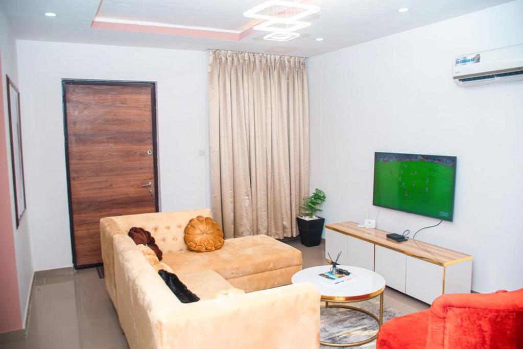 a living room with a couch and a flat screen tv at willy's apartment in Lagos