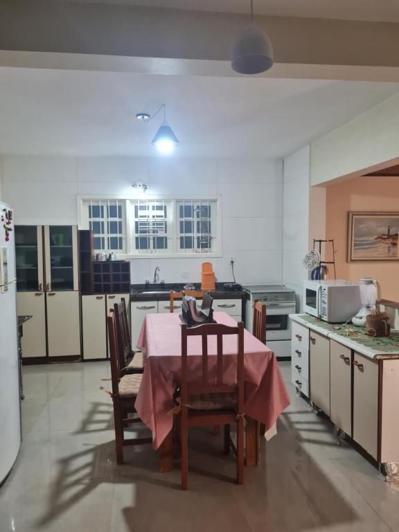 una cucina con tavolo e tovaglia rosa di Casa aluguel temporada _Torres a Torres