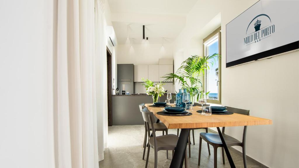 Un comedor y una cocina con mesa y sillas de madera. en APPARTAMENTO - Molo del Porto A, en Civitavecchia