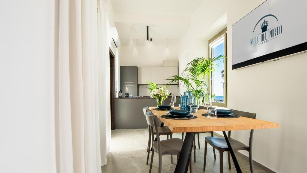 a dining room and kitchen with a wooden table and chairs at Molo del porto in Civitavecchia