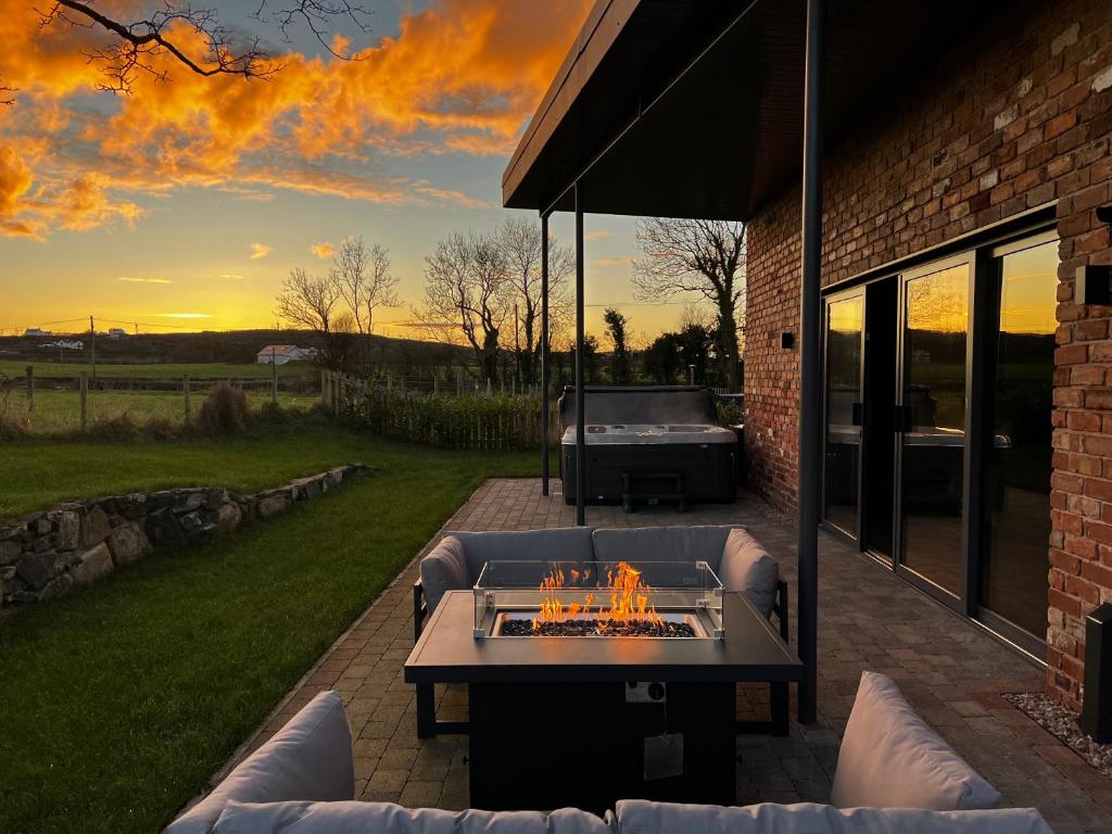 a patio with a couch and a fire pit at The Barn at Corrstown Village in Portrush