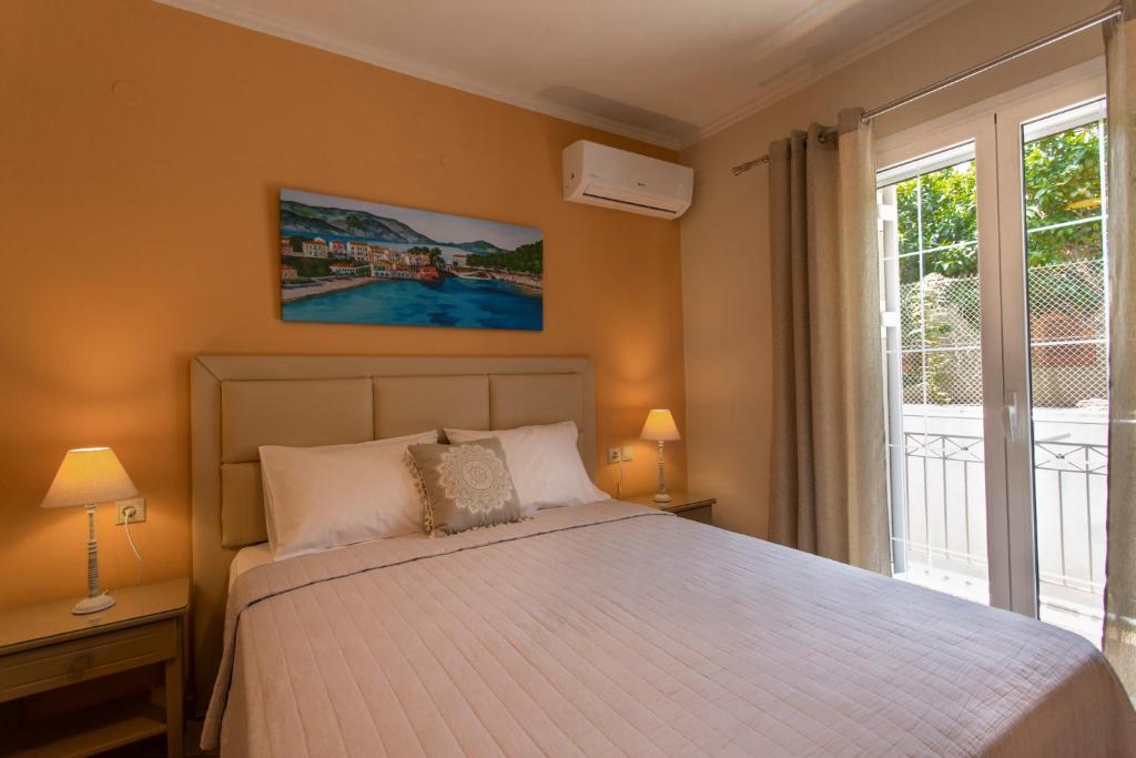 a bedroom with a bed and a large window at Dina Apartments Argostoli in Argostoli